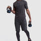 Man lifting kettlebells in training tops and shorts